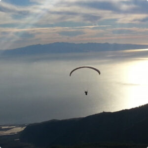 Paraglide in der Luft mit Blick über das Meer bei Sonnenuntergang